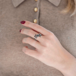 Sterling silver leaf guard wedding band and oval salt and pepper (Herkimer diamond) engagement ring displayed in hand against warm brown backdrop