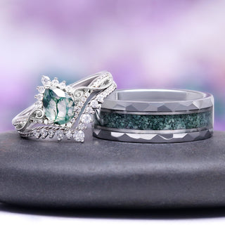 Two rings with green gemstones on a gray surface against a purple gradient background