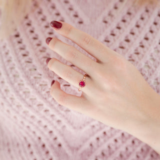 Vintage Ruby Ring in 14K Rose Gold Vermeil by Aquamarise, featuring a vibrant red ruby in a delicate rose gold setting worn on a hand over a soft pink textured knit garment.