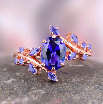 Lab-Grown Oval Cut Cornflower Sapphire Leaf Engagement Ring in 14K Solid Rose Gold by Aquamarise Gold with intricate leaf details and a vibrant oval cornflower sapphire center stone.