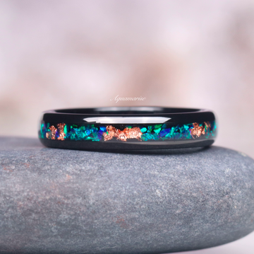 Peacock Fire Opal & Rose Gold Leaf Couples Ring Set by Aquamarise featuring a black band inlaid with vibrant peacock fire opal and shimmering rose gold leaf accents.