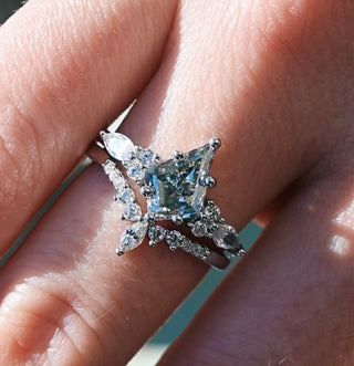Silver ring with a large central gemstone on a person's finger