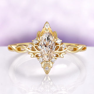 Gold ring with a marquise-shaped diamond on a light purple background
