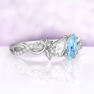 Angled view of the toi et moi leaf vine ring, showing the twisted band with a row of round cubic zirconia leading to the two stones
