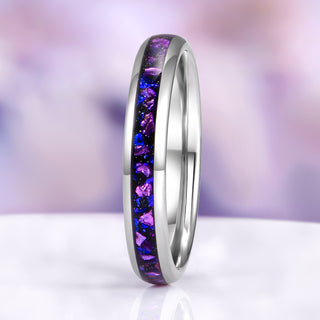 Silver ring with purple and blue gemstones on a blurred purple background