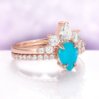 Rose gold ring with a turquoise heart-shaped gemstone on a white surface with a purple background