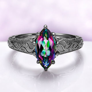 Victorian Gothic Mystic Topaz Filigree Engagement Ring in Black Ruthenium by Aquamarise featuring a marquise mystic topaz and detailed Victorian scrollwork on a black ruthenium silver band.