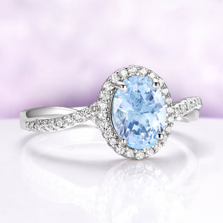 Silver ring with a blue gemstone on a light purple background
