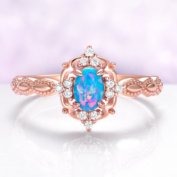 Rose gold ring with a blue opal stone and diamond accents on a white background