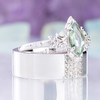 Angled view of the Viridian green tourmaline ring resting on the matching men's band, sold together as a couples set