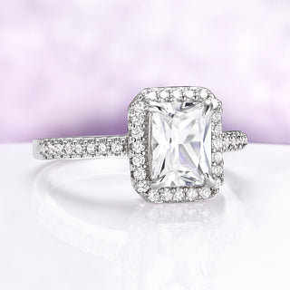 Diamond ring with a large central gemstone and smaller stones on a gradient background