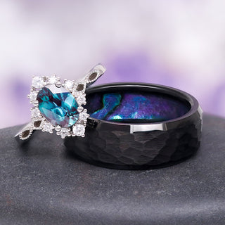 Black ring with blue gemstone and diamond accents on a gray surface with a purple gradient background