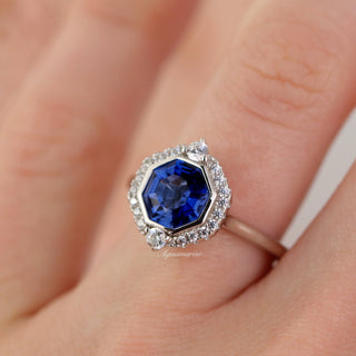 Asscher Cut Art Deco Bezel Set Blue Sapphire Ring in Sterling Silver by Aquamarise, featuring a deep blue sapphire with halo of sparkling stones on a polished silver band.