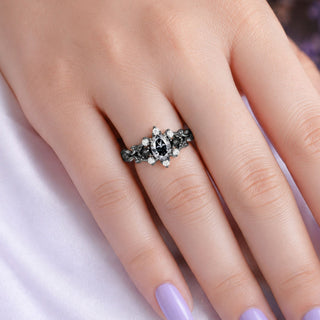Black ruthenium marquise engagement ring with pave accents worn on a hand with lilac nails, Aquamarise lifestyle banner