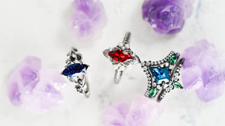 unique black engagement rings with colorful gemstones on a light purple floral background