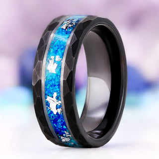 Blue Fire Opal men's wedding band in hammered black tungsten, 8mm, standing at an angle to show the silver-edged channel of blue opal and silver leaf