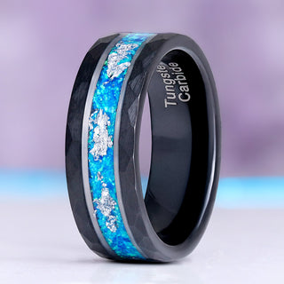 Blue Fire Opal men's wedding band standing upright, hammered black tungsten carbide with a blue opal inlay flecked with silver leaf