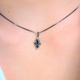 Model wearing the Carmilla gray moissanite and black onyx pendant necklace in black ruthenium