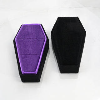 Black and purple velvet coffin ring box shown from above beside its black lid