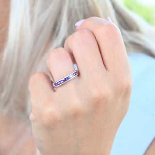 Crushed alexandrite and fire opal 4mm tungsten wedding band worn on a model's hand