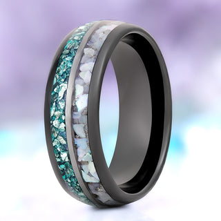 Crushed aquamarine and pearl men's wedding band in polished black tungsten, 8mm, second standing view of the teal and white off-set inlay