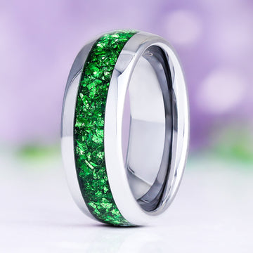 Crushed emerald men's wedding band standing upright, polished silver tungsten carbide with a crushed green emerald inlay