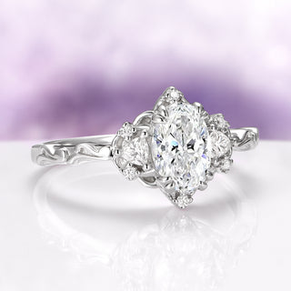 Silver ring with a oval-shaped diamond on a light purple background