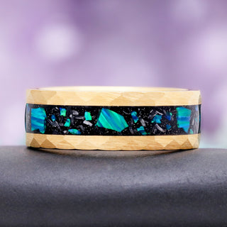 8mm Fire Opal and meteorite men's wedding band in gold tungsten carbide resting on a dark stone, showing the blue opal and meteorite inlay