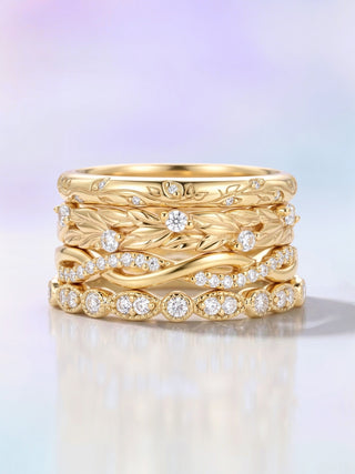 Stack of gold rings with diamond accents on a gradient background