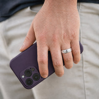Man wearing the 6mm Gray Moissanite Celestial wedding band in sterling silver, bezel-set marquise gray moissanite with pave crescent moons and star accents