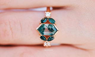 Close-up of a green gemstone pendant on a finger