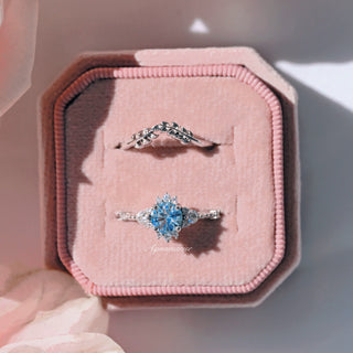 Filigree Leaf Wedding Band in 14K White Gold shown with a sparkling blue gemstone ring, displayed in a pink velvet jewelry box by Aquamarise Gold.