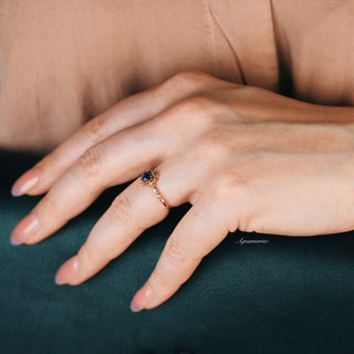 Vintage Alexandrite Fairytale Engagement Ring in 14K Rose Gold Vermeil by Aquamarise, featuring a blue-green color-shifting gemstone and delicate rose gold detail on a hand with natural nails.