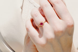 Vintage Ruby Ring in 14K Rose Gold Vermeil by Aquamarise, featuring a rich red ruby set in an elegant rose gold band, worn on a hand against a soft neutral fabric background.