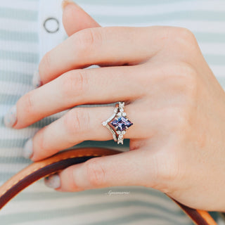 Kite Alexandrite Ring Set- Sterling Silver by Aquamarise, featuring a kite-cut alexandrite gemstone with sparkling diamond accents, shown on a hand holding a brown leather strap.