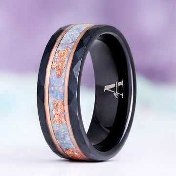 Light Blue Fire Opal men's wedding band standing upright, hammered black tungsten with rose gold rails and a blue opal inlay flecked with rose gold