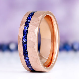 Midnight Blue Sapphire men's wedding band standing upright, hammered rose gold tungsten with a crushed blue sapphire inlay