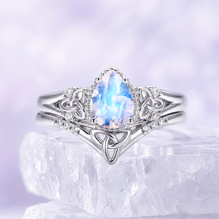 Sterling silver moonstone bridal set with marquise moonstone center and Celtic trinity knot band resting on a raw white crystal, Aquamarise collection banner