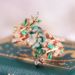 Gold ring with green gemstones on a textured surface