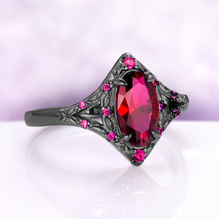 Angled view of the Nerida ruby ring, showing the split shank with engraved leaves and small lab-grown ruby accents leading to the oval center