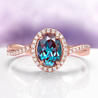 Rose gold ring with a blue gemstone on a white surface