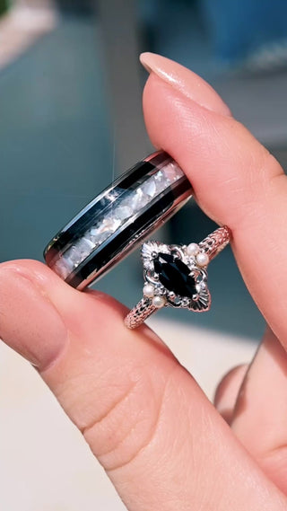 Video of the Arwen Black Onyx & Pearl Couples Ring Set by Aquamarise, the marquise onyx ring and the men's onyx and pearl tungsten band held together in sunlight
