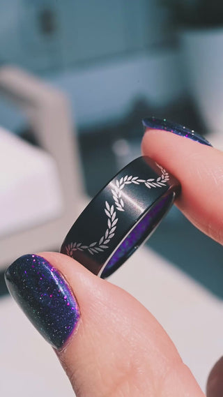 Video of the laurel vine black titanium band in motion, showing the etched leaves and the lavender opal sleeve inside