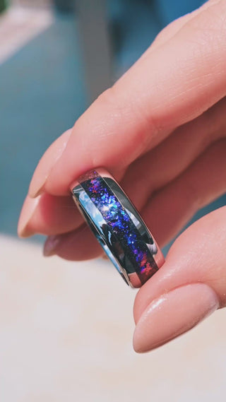Video of the Orion Nebula Fire Opal Men's Wedding Band in Silver Tungsten Carbide (8mm) by Aquamarise held outdoors, blue and violet fire opal inlay catching the light