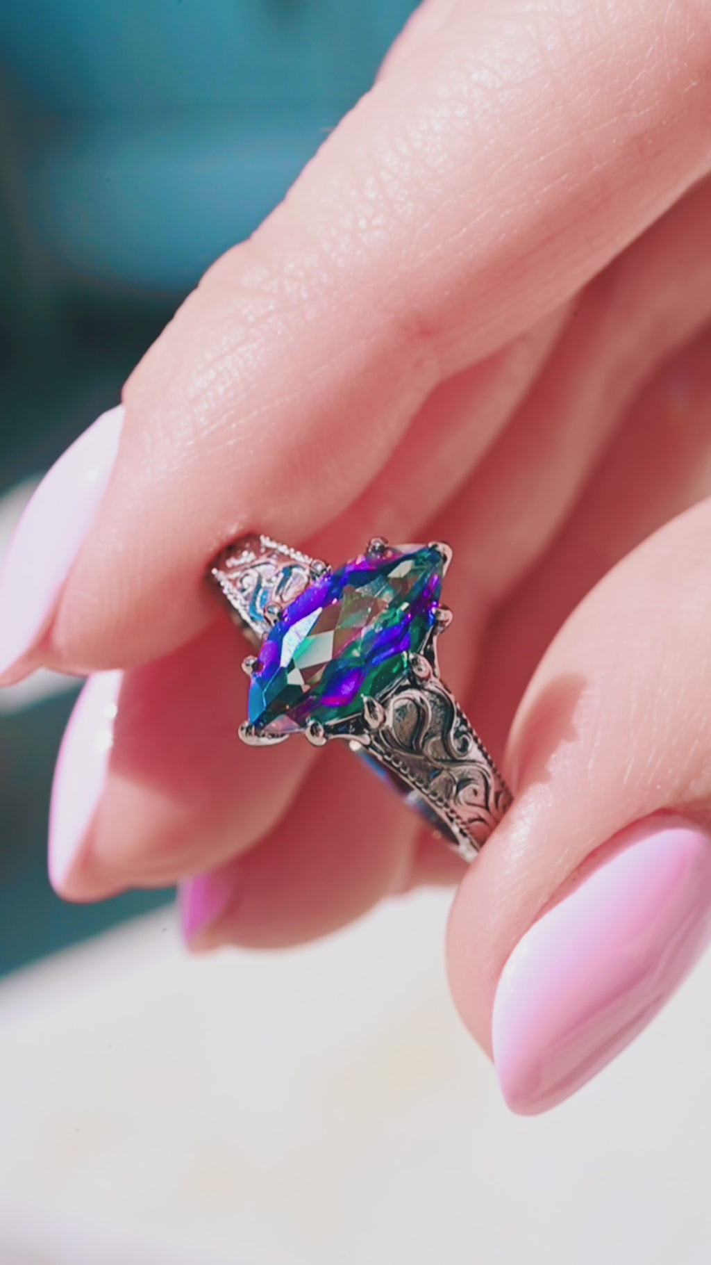 Video of the mystic topaz scrollwork ring by Aquamarise, shown in motion