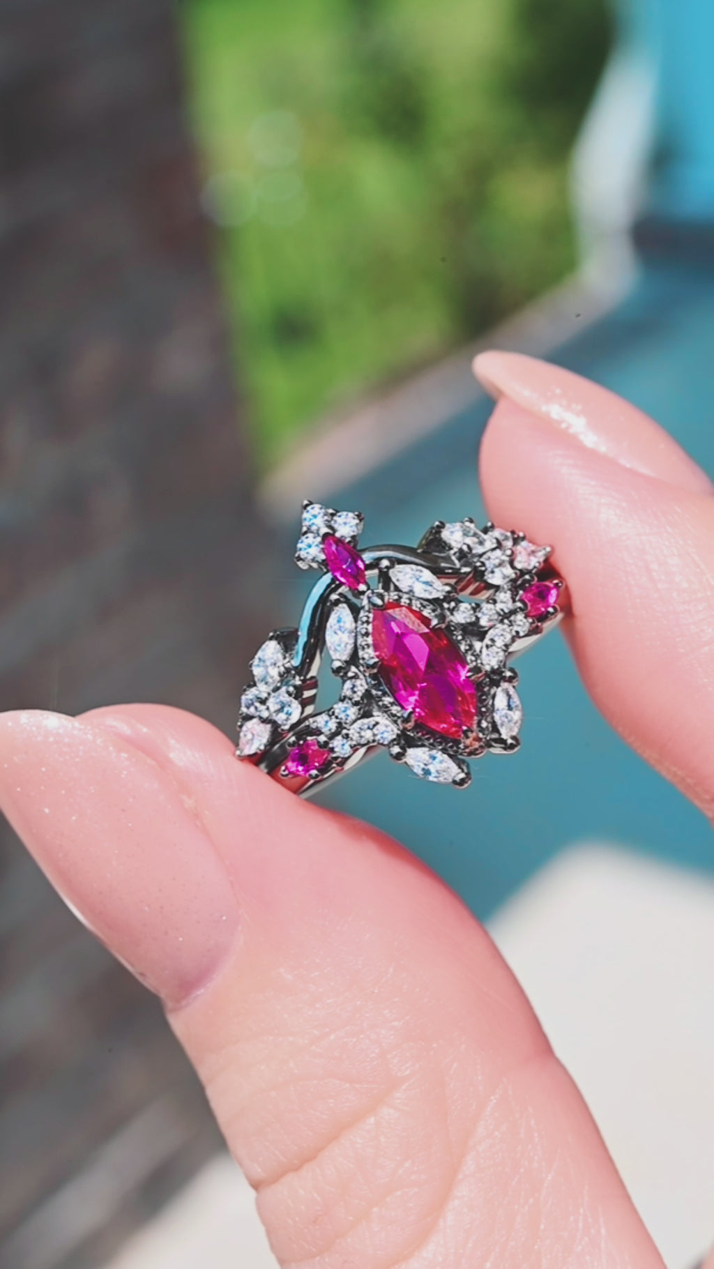 Nightbriar lab-grown ruby bridal ring set in black ruthenium turning in daylight, showing the stacked engagement ring and matching band