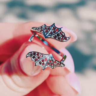Natural garnet trillion bat ring set in black ruthenium video — the bat wing band alone, then paired with the trillion garnet center and worn on the finger
