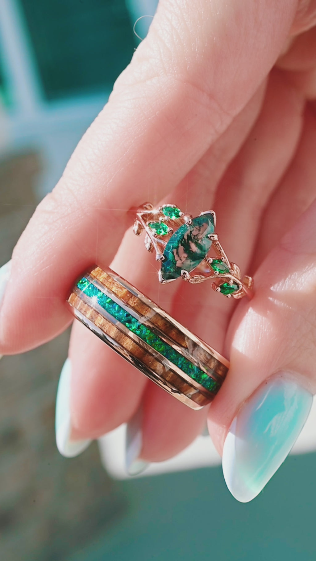 hand holding nature inspired couples ring set moss agate and opal