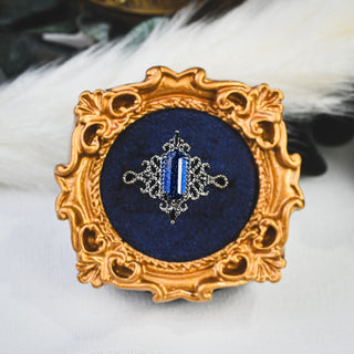 Ravenna Hexagon Starry Night & Black Onyx Engagement Ring in Black Ruthenium displayed in an ornate gold frame