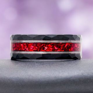 8mm Red Garnet men's wedding band in two tone tungsten carbide resting on a dark stone, showing the crushed garnet inlay and silver rails